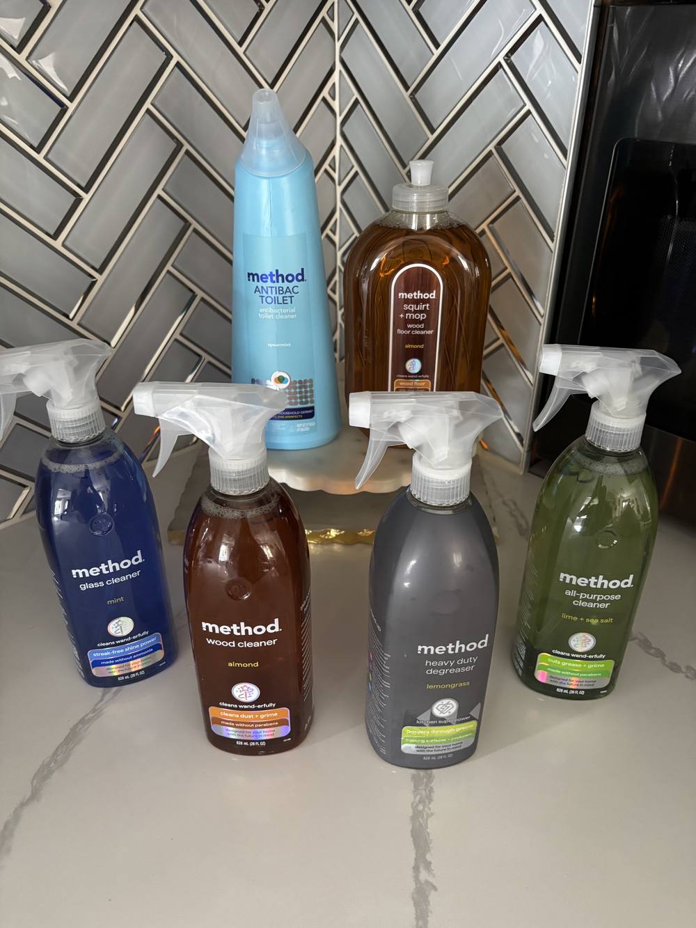 Cleaning products used by Clean and Shiny arranged on a marble counter